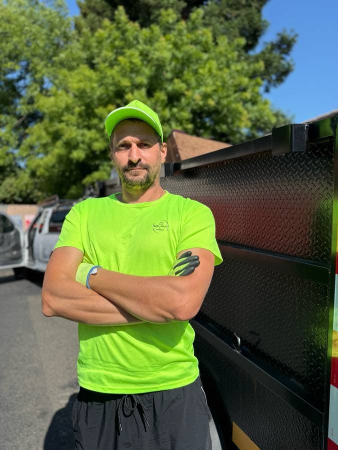 Sacramento junk removal company owner standing beside dumpster trailer ready for hauling service