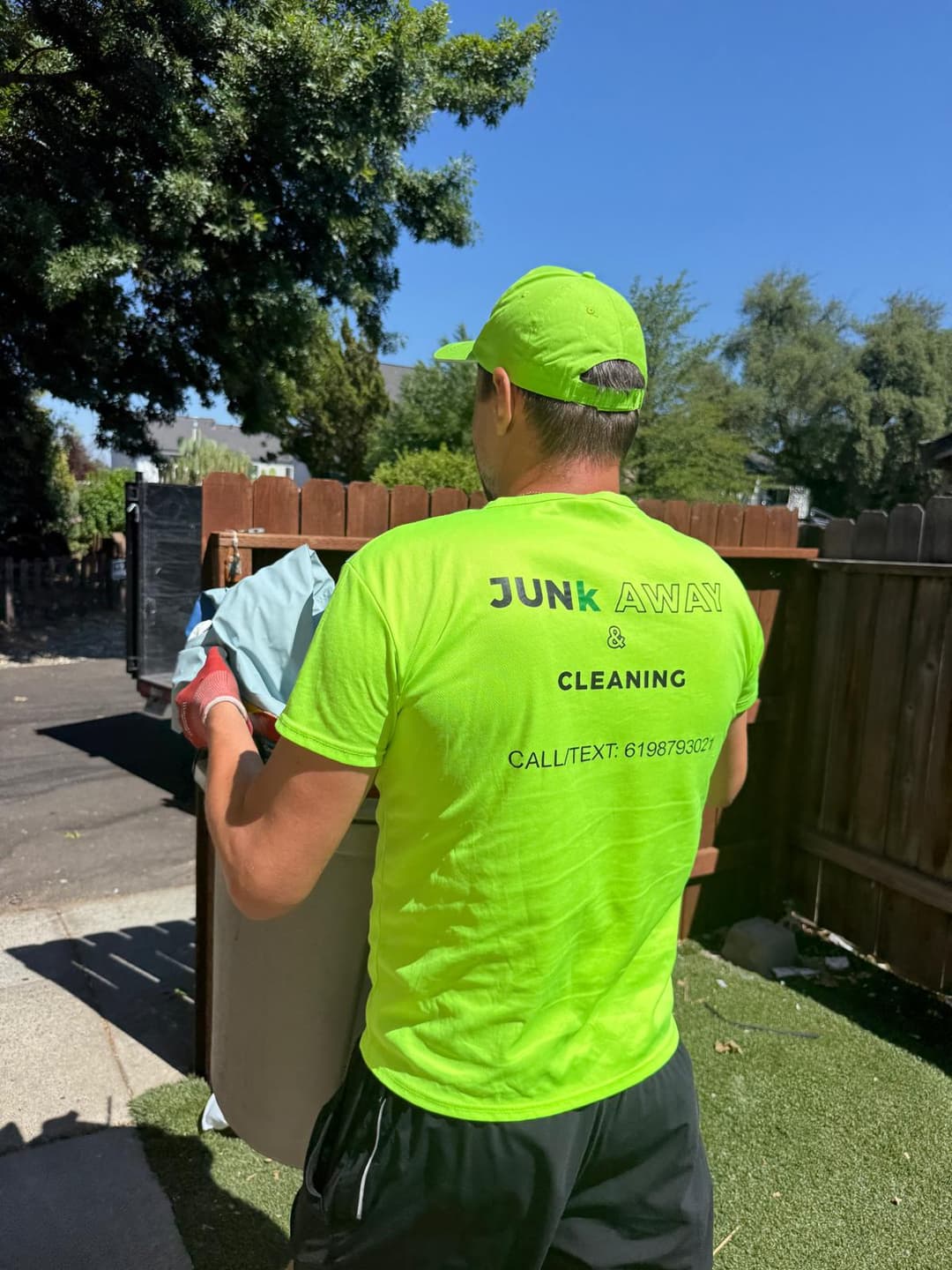 Owner of Sacramento junk removal company carrying garbage bucket during cleanup service