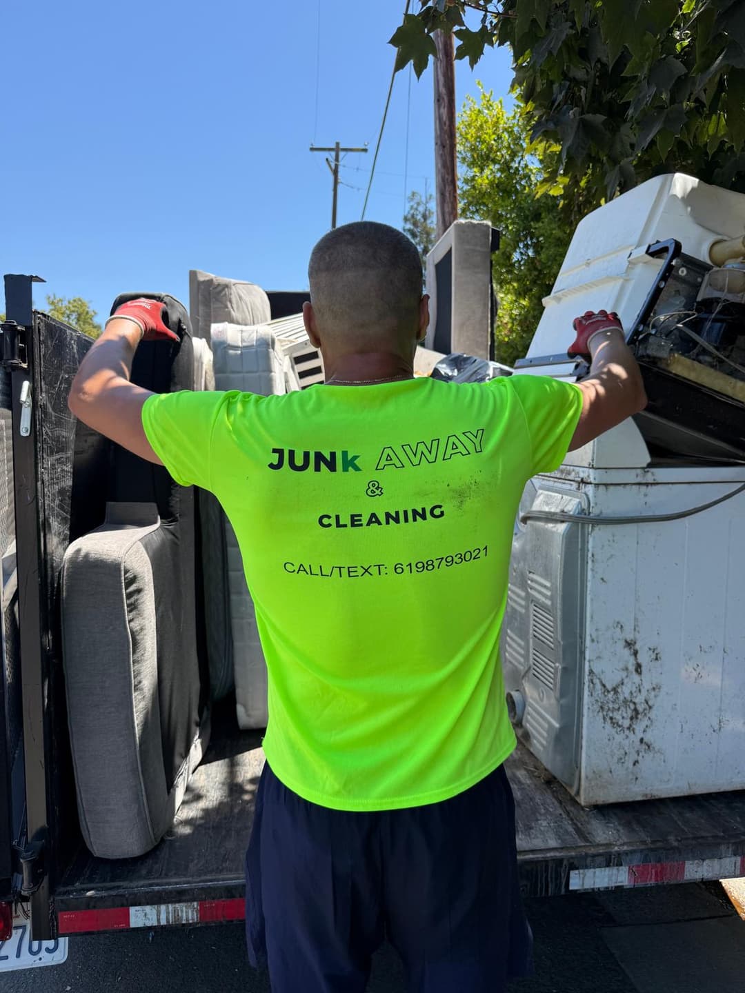 Owner of Sacramento junk removal company loading trailer full of garbage and debris